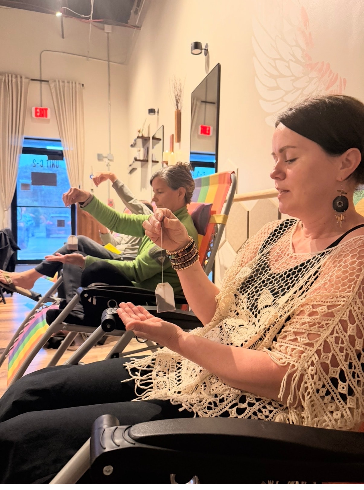 Participants practicing pendulum dowsing at Psychic Game Night, Mindful Way Studio