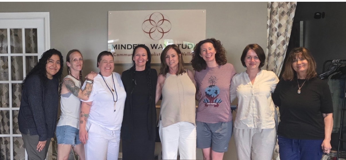 Eight people group photo in front of the Mindful Way Studio sign