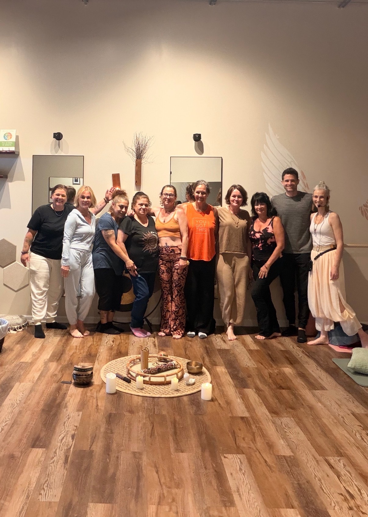 Group of people standing together after an event, angel wings mural behind them