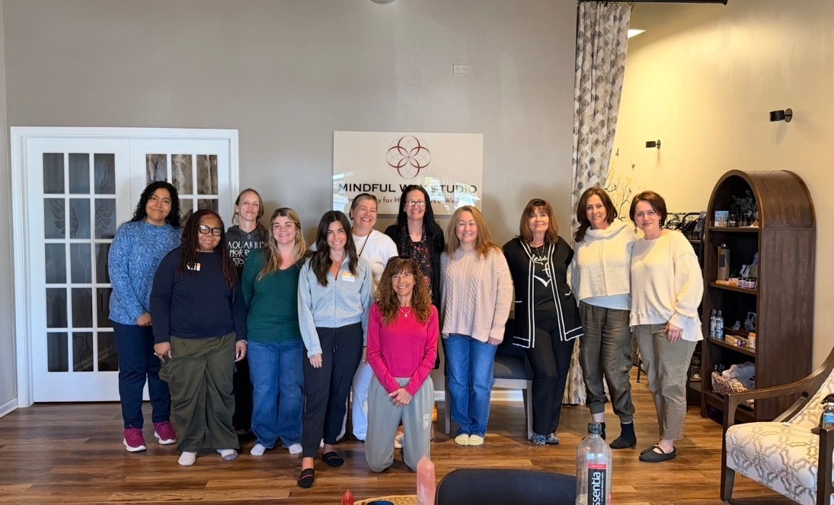 Large group of 13 people in front of the Mindful Way Studio sign