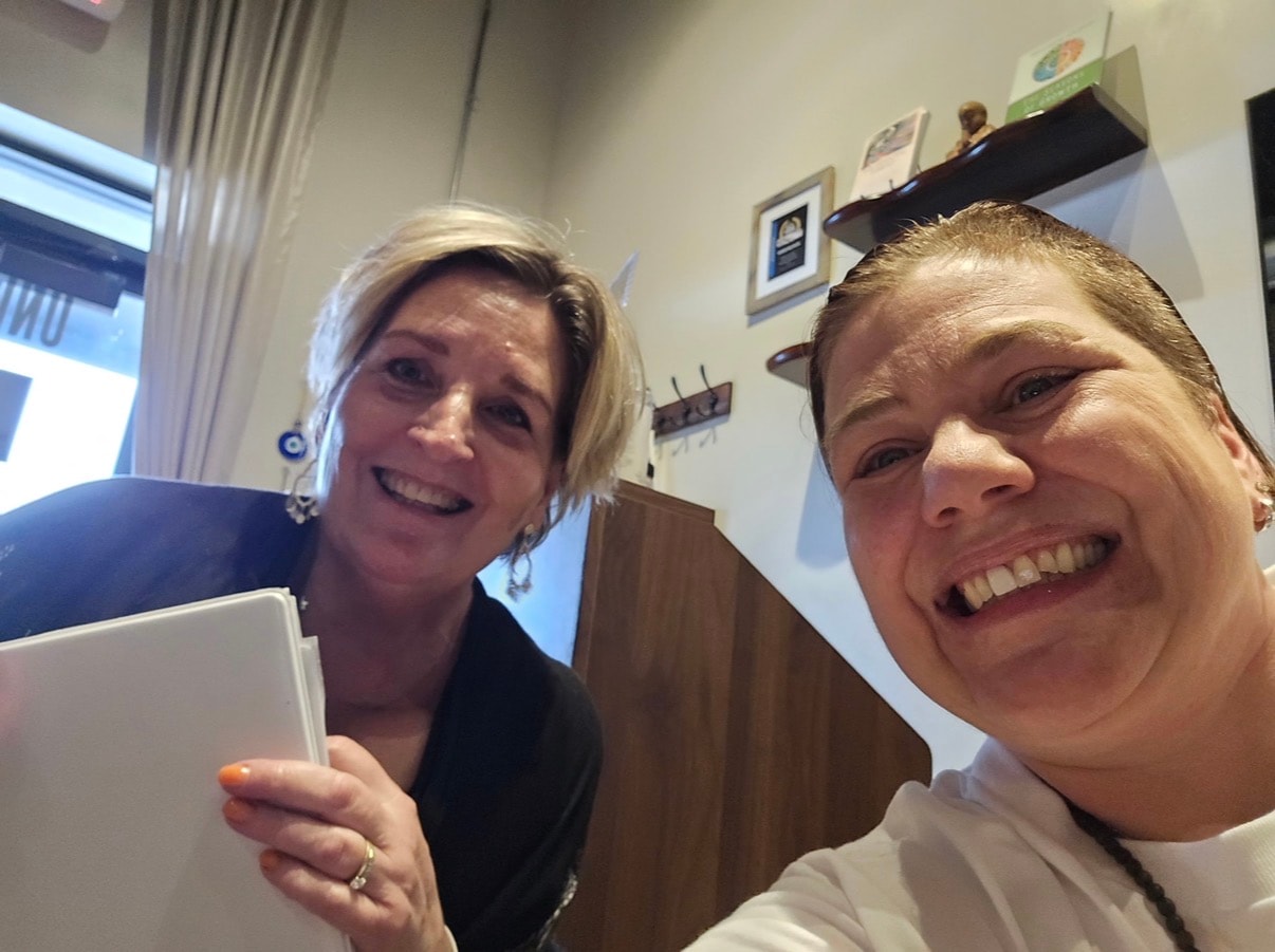 Two women smiling selfie in the studio office