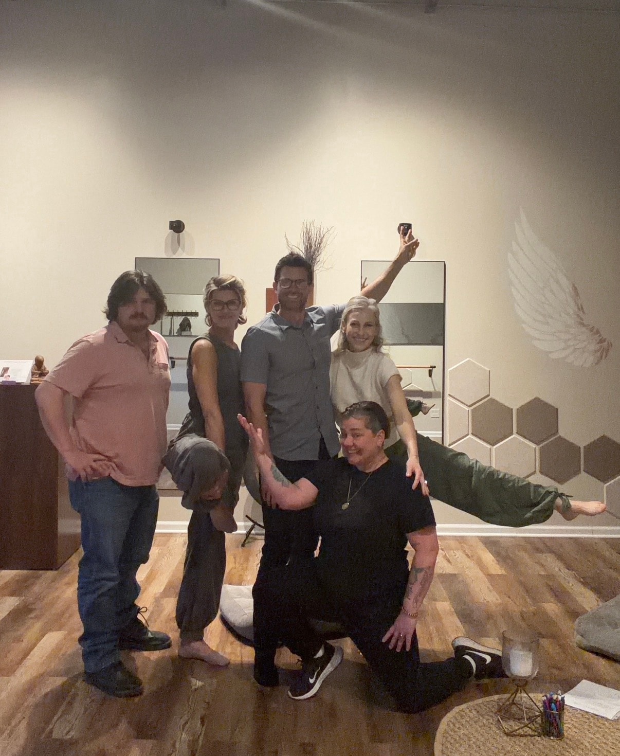 Fun group photo with someone doing a split mid-air, everyone laughing
