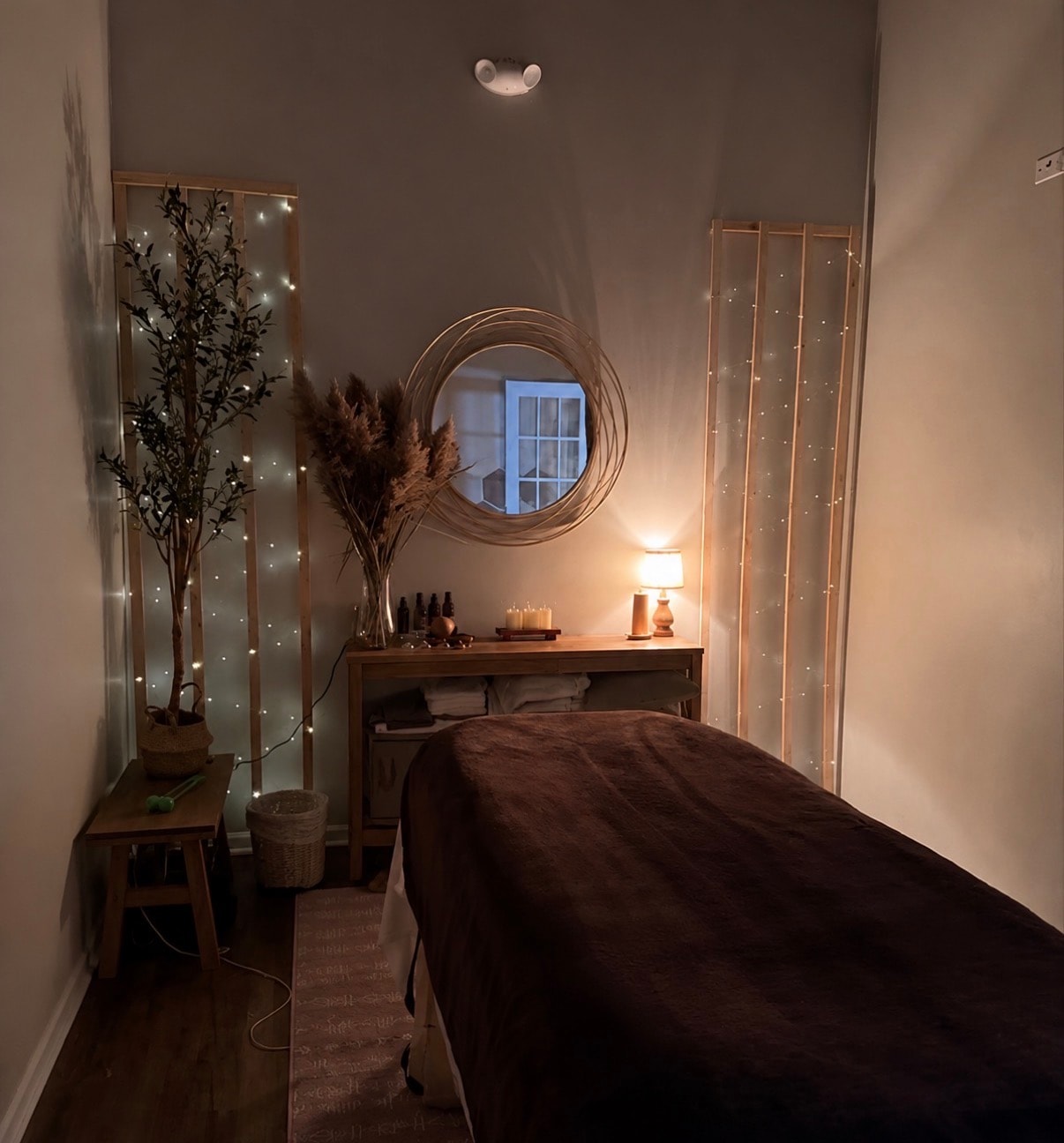 Cozy treatment room with fairy lights and massage table