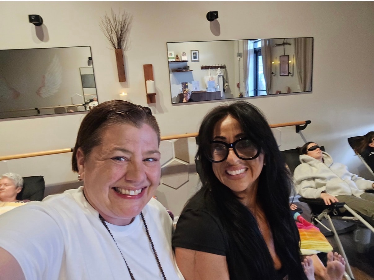Two women smiling selfie during a sound bath event