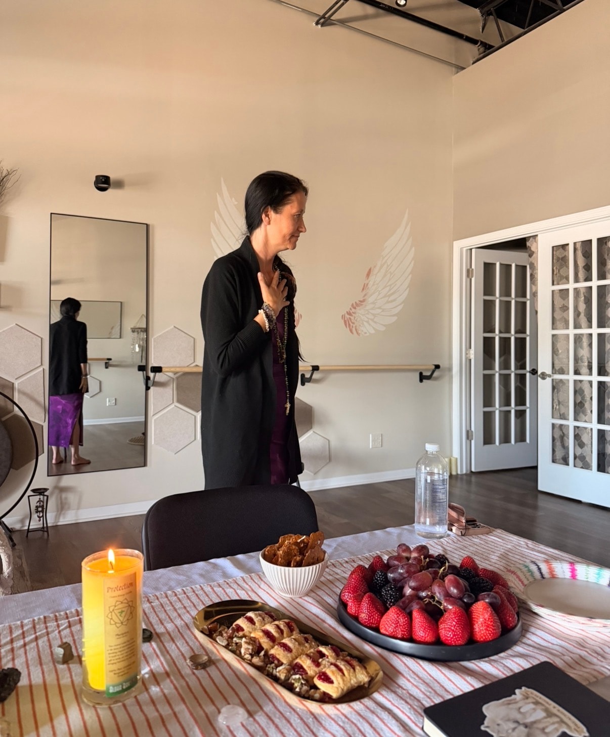Ania Haas leading a workshop at Mindful Way Studio with angel wings mural and candles, Mokena IL