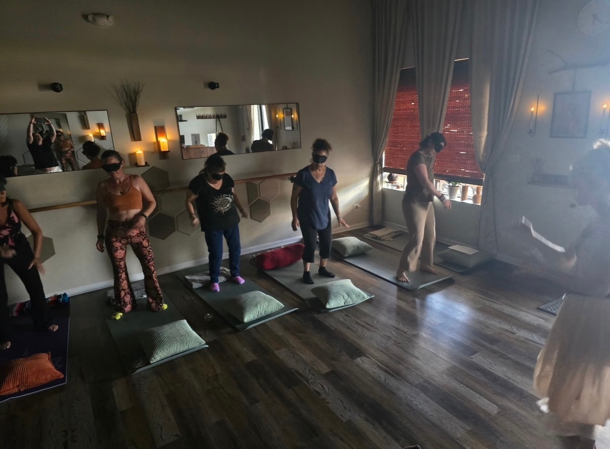 Blindfolded movement class with participants standing on mats