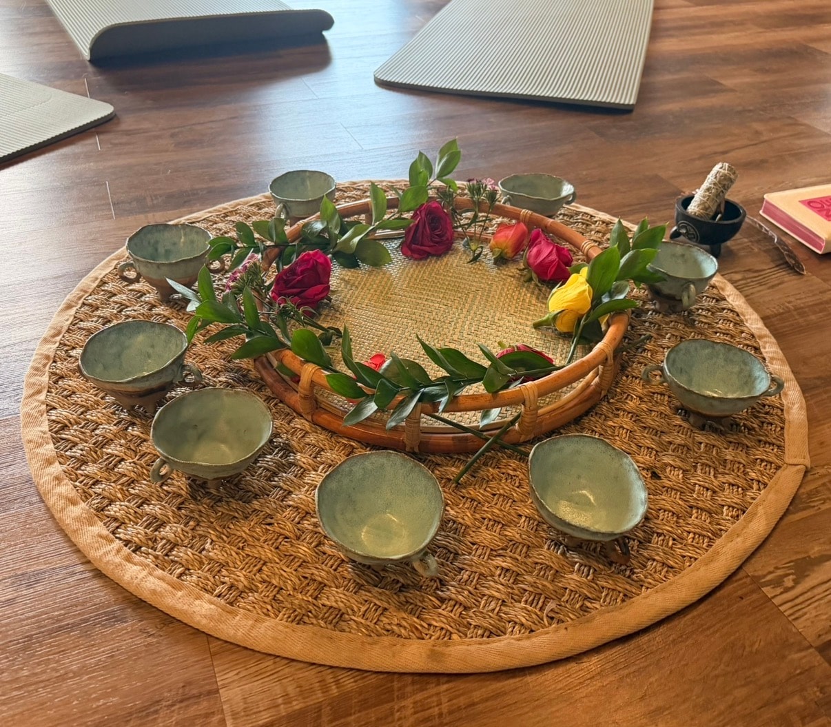 Ceremonial cacao altar with handcrafted bowls, roses and greenery arranged in a circle at Mindful Way Studio, Mokena IL