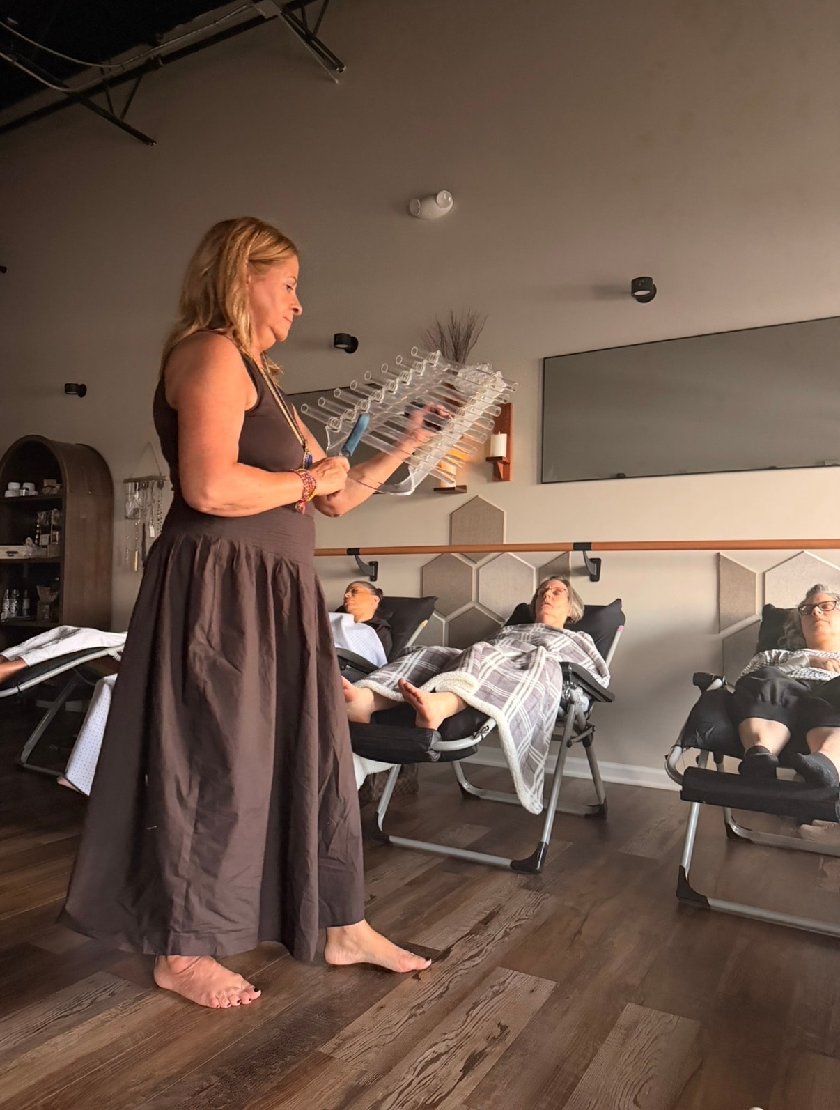 Instructor holding a crystal harp over reclining participants