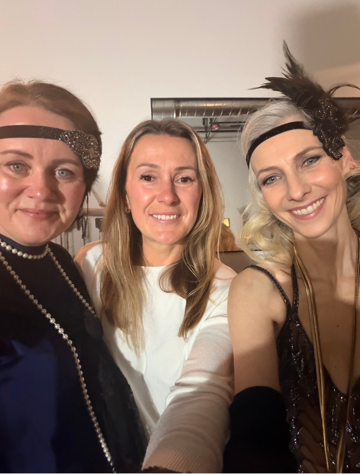 Three women in 1920s Gatsby costumes at the themed wellness party