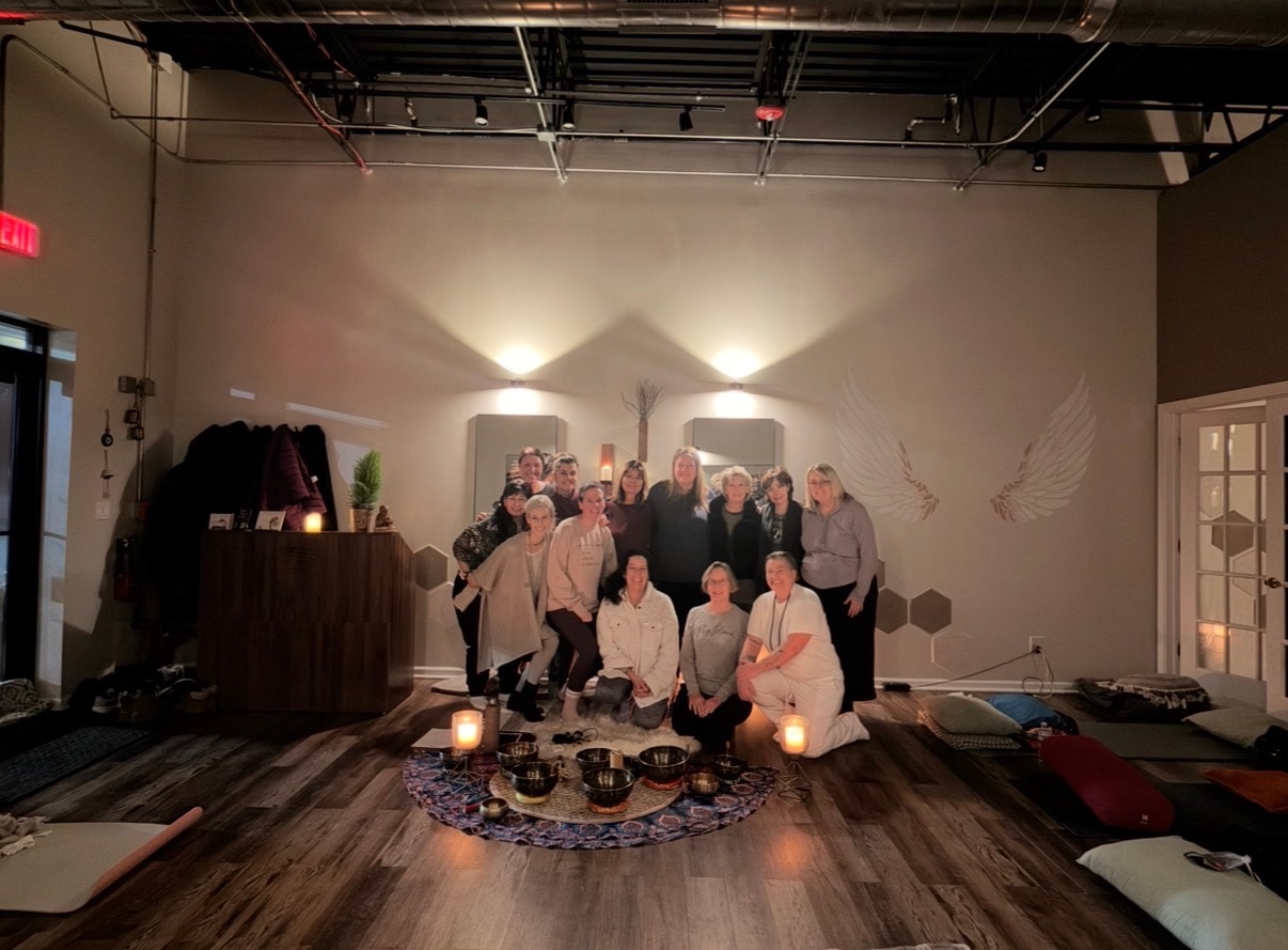 Group photo after a sound bath event in front of the angel wings mural