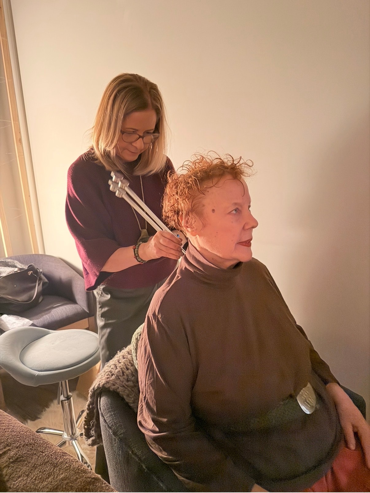 Tuning fork session with practitioner working on a seated client