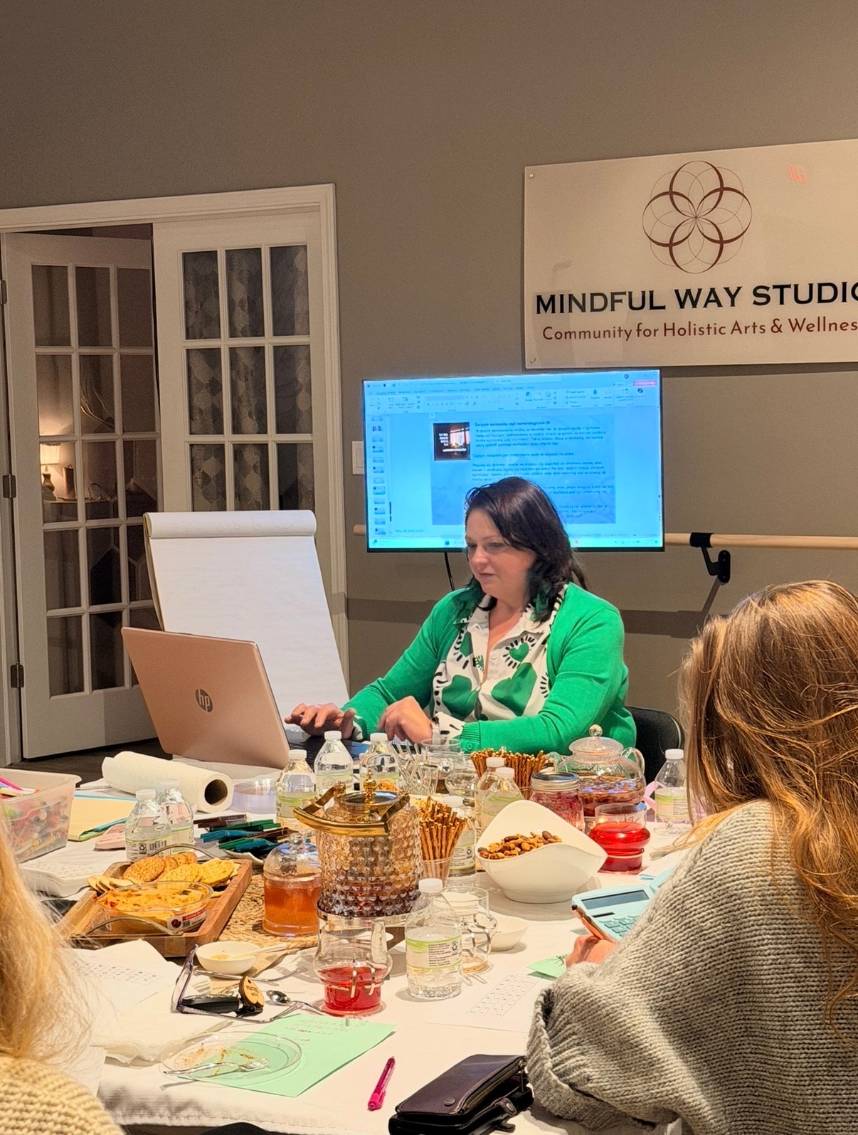 Workshop in progress with presenter at laptop and attendees at table