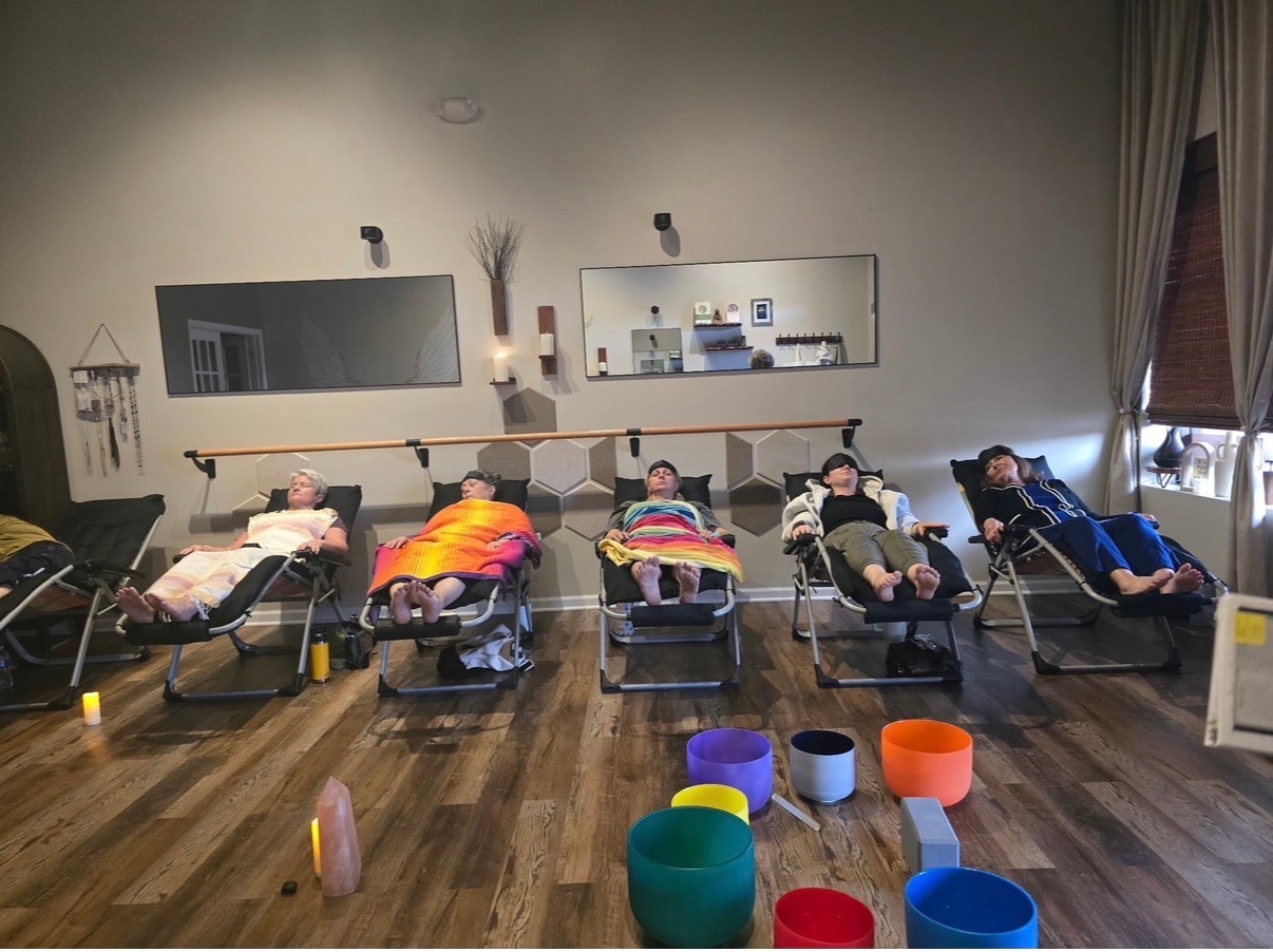 Five people reclined in zero-gravity chairs during a sound bath