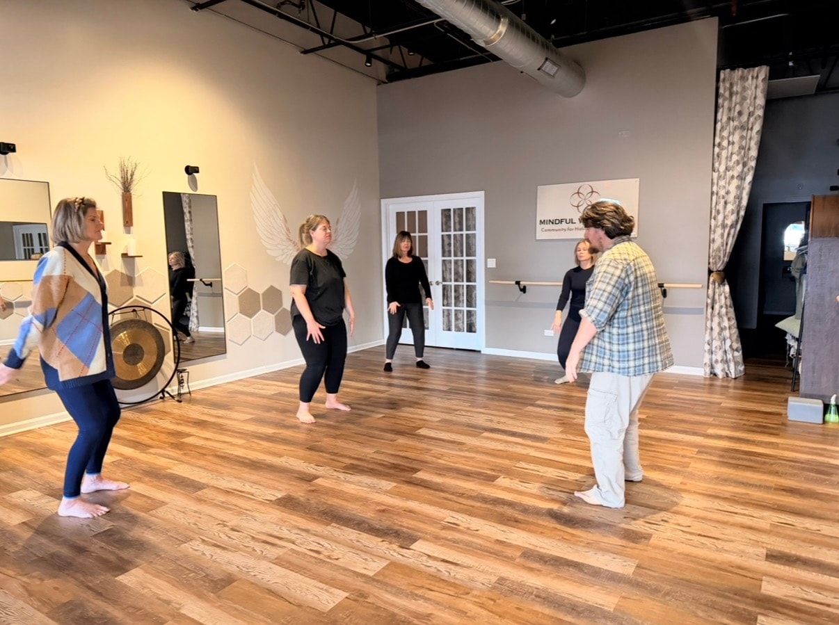 Movement class with five participants in the studio